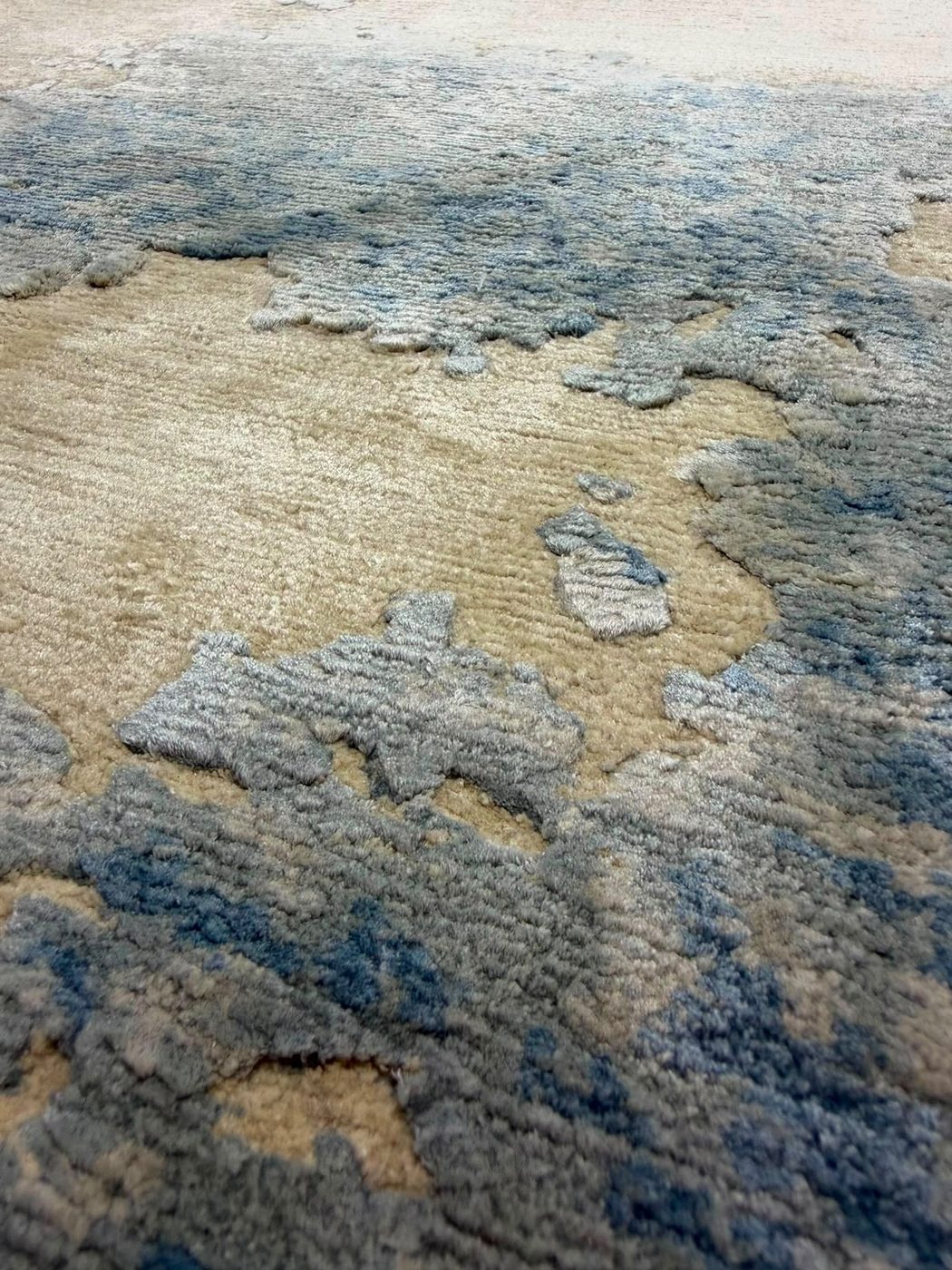 Close-up of the raised blue silk pile against the lower ivory ground