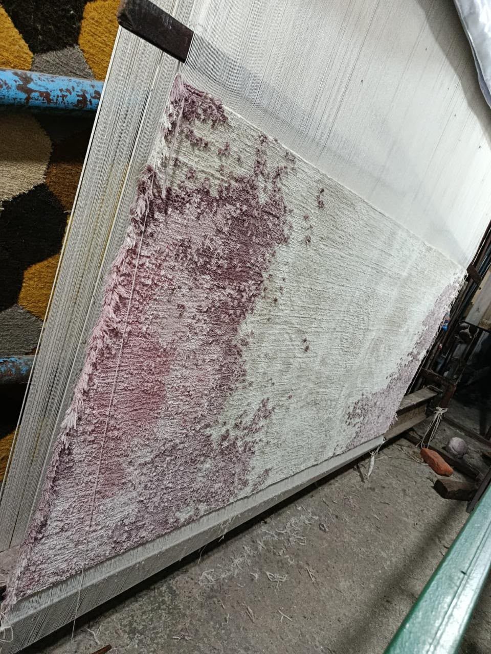 The rug half knotted on an upright loom